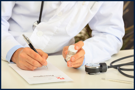 67327979 - doctor writing a perscription on his desk
